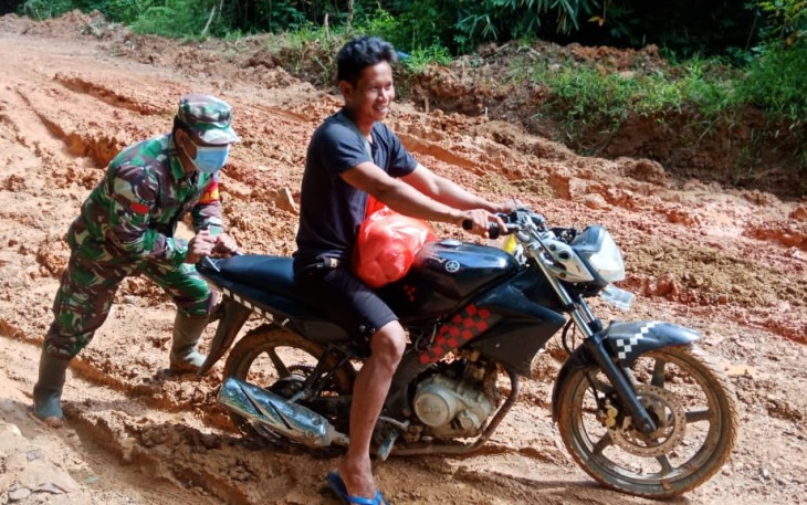 Dengan Sigap Babinsa Anggota Koramil  17/Silat Hulu Bantu Warga Dorong Motor