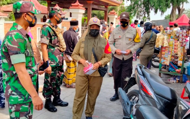 Petugas Patroli Gabungan membagikan masker kepada masyarakat yang berziarah di Jabal Nur Protomulyo. Senin 22/11/2021
