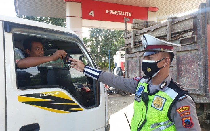 Anggota Satlantas Polres Kendal berikan masker kepada  pengendara mobil yang lewat di depan SPBU Jambe Arum