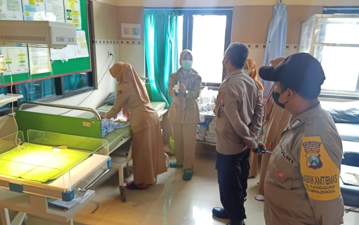 Petugas Medis Puskesmas Kepanjenkidul Kota Blitar Didampingi Polisi Saat Memeriksa Bayi yang Terbungkus Dalam Tas Ransel Warna Hitam yang Ditemukan Warga