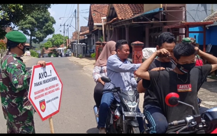 Anggota Koramil 07/Bandar Kodim 0736/Batang membagikan masker kepada para penguna jalan yang tidak mengenakan masker di Jalan Binangun Kecamatan Bandar, Kabupaten Batang, Selasa (28/9/21).