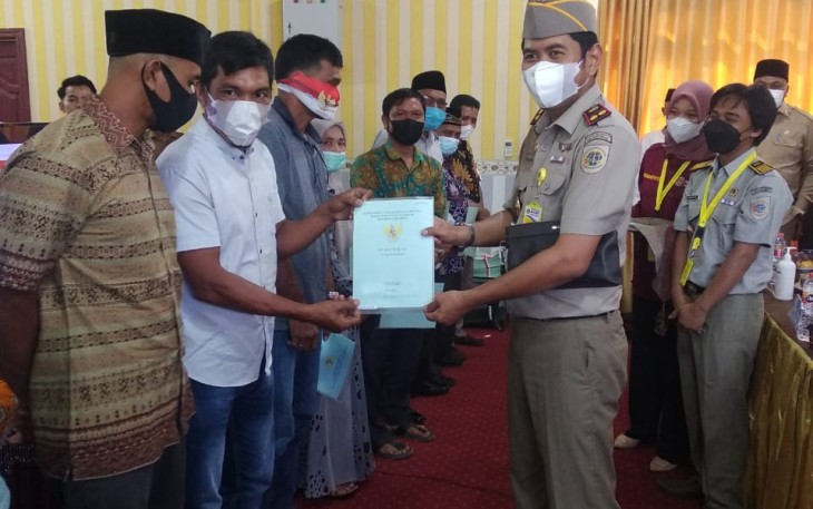 Kepala Kantor Pertanahan Aceh Singkil, Muhammad Reza,S.T, M.Si, saat menyerahkan sertifikat tanah masyarakat dengan Protkes.