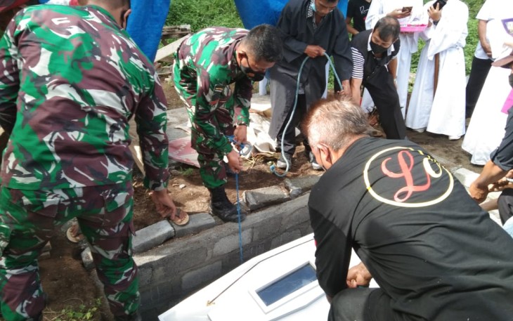 Sejumlah personel satgas TMMD kodim Bitung saat bantu turunkan peti jenazah