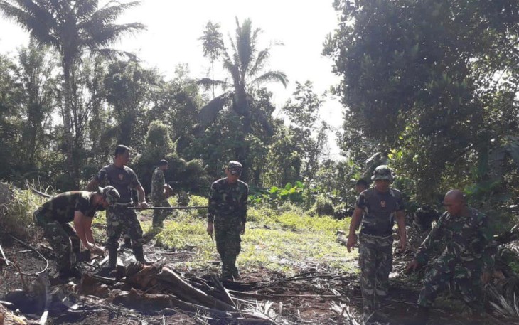 Personil kodim 1310/Bitung sedang mempersiapkan lahan untuk tanam jagung.