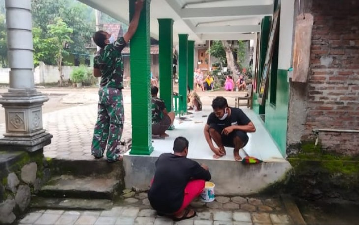 Anggota Koramil Jogorogo Gotong Royong Bantu Warga Pengecatan TPA