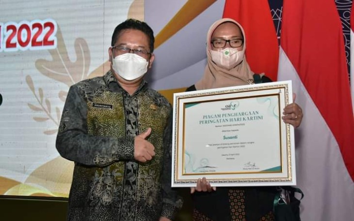 Penjabat Sekdakab Trenggalek Andriyanto, saat mendampingi Susanti, menerima penghargaan Puncak Hari Kartini, di Gedung Negara Grahadi Surabaya, Kamis (21/4/2022).