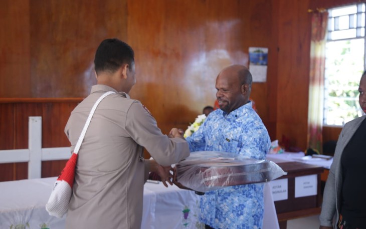 Pendeta Gundius Wandikmo menerima alat musik gitar dari IPDA Murtono SH. Minggu (15/05/2022) 