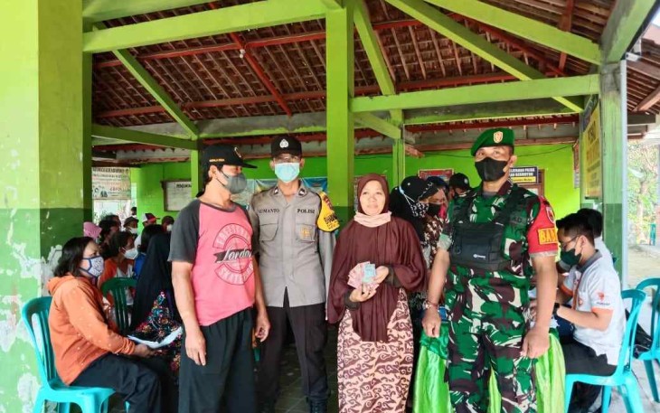 Serka Juhartono dampingi warga binaannya saat pengambilan BLT DD di balai desa Klumutan