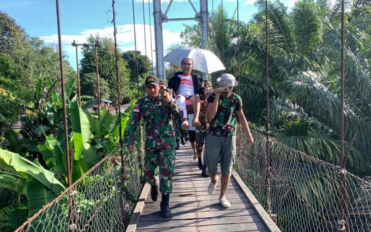 Tandu warga yang sakit melintasi jembatan gantung di perbatasan 