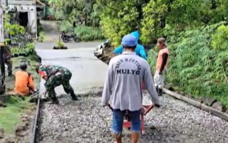 Serka Erwan saat meratakan cor jalan di desa binaan