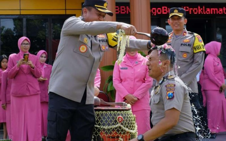 Kapolres Blitar Kota AKBP Argowiyono saat menyiram air bunga anggotanya naik pangkat
