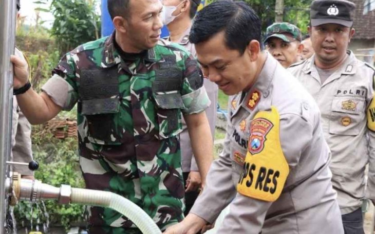 Kapolres saat menuangkan langsung air bersih dari tangki