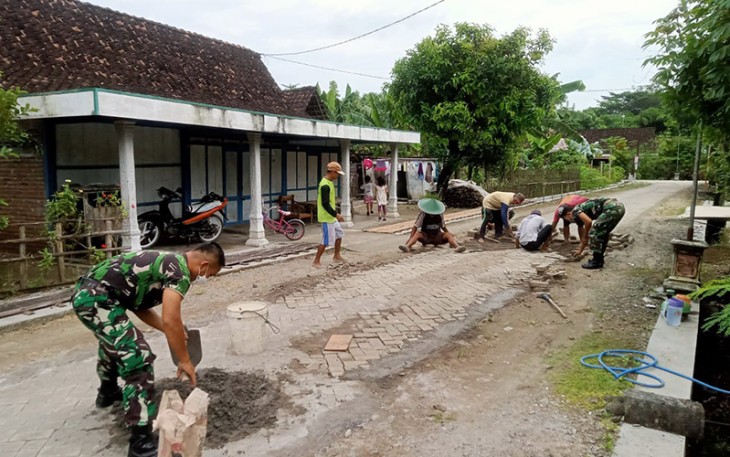 Serda Naryo Bersama Warga saat Gotong-Royong Perbaiki Jalan 