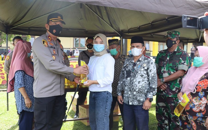 Kapolres Lebong Polda Bengkulu AKBP Awilzan, S.IK, didampingi Pabung Kodim 0409/RL dan Staf Ahli Bupati serta Kadinkes saat memberikan minyak goreng ke salah satu peserta vaksinasi