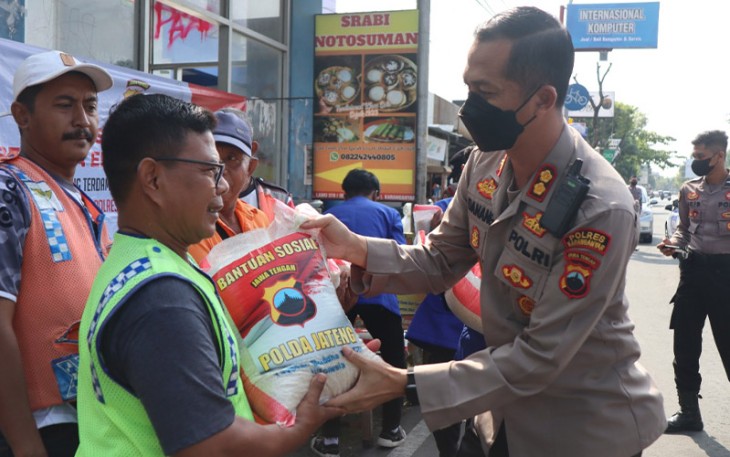 Kapolres Karanganyar AKBP Danang Kuswoyo sedang menyerahkan bantuan beras kepada sejumlah warga yang berada di sekitar lingkungan Mapolres Karanganyar, Jumat (30/9/2022).