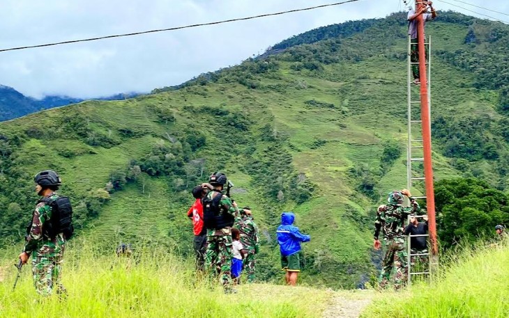 Satgas Yonif Raider 142/KJ dan beberapa orang warga saat bantu memperbaiki instalasi Listrik Solarsel yang diperkirakan mengalami konsleting.