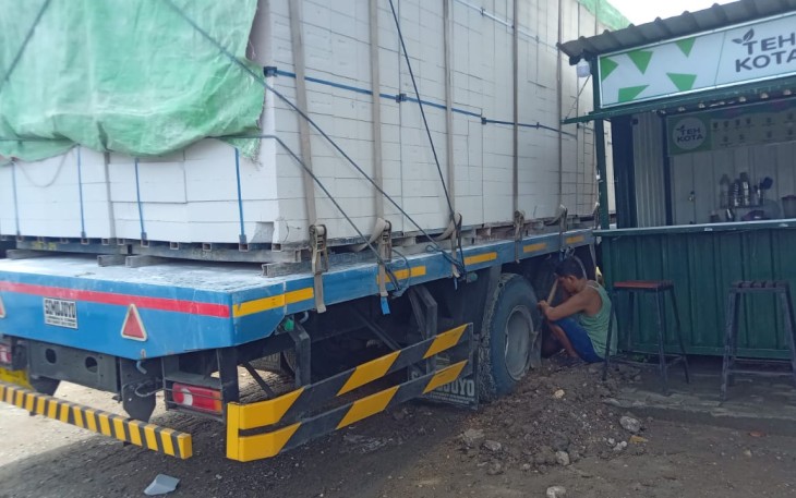 Truk bermuatan bata ringan yang terperosok di bekas galian pipa milik Pertamina EP di desa Pojokwatu kecamatan Sambong kabupaten Blora.