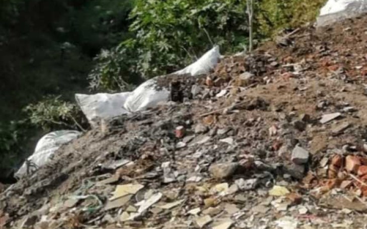 Penimbunan sampah bekas material bangunan di bantaran kali Curah Banteng