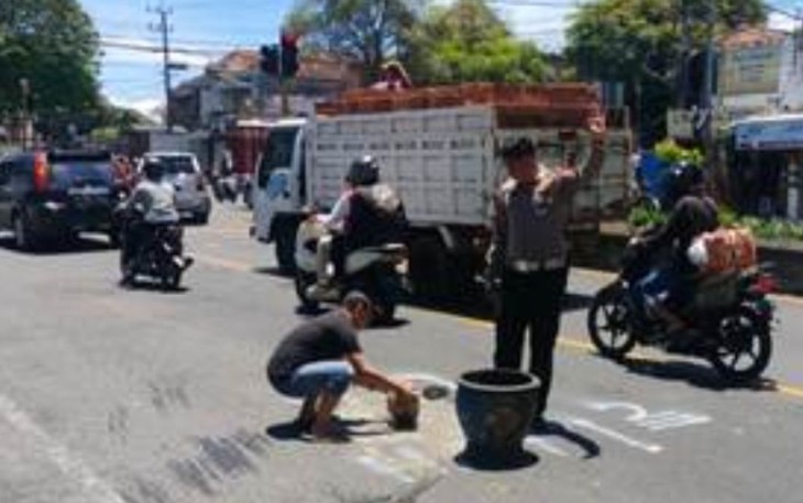 Bripka Agus Setiawan bersama masyarakat saat tambal jalan