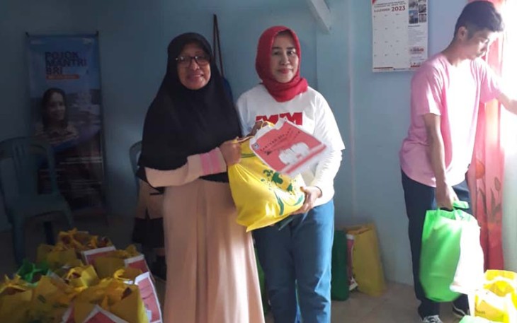 Kadis Lingkungan Hidup jilbab merah saat memberikan paket sembako kepada warga