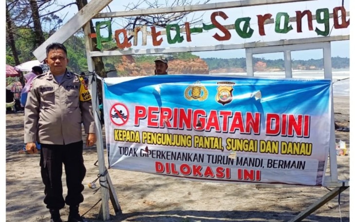 Personel Polsek Batik Nau Pasang Spanduk Dilarang Mandi di Pantai