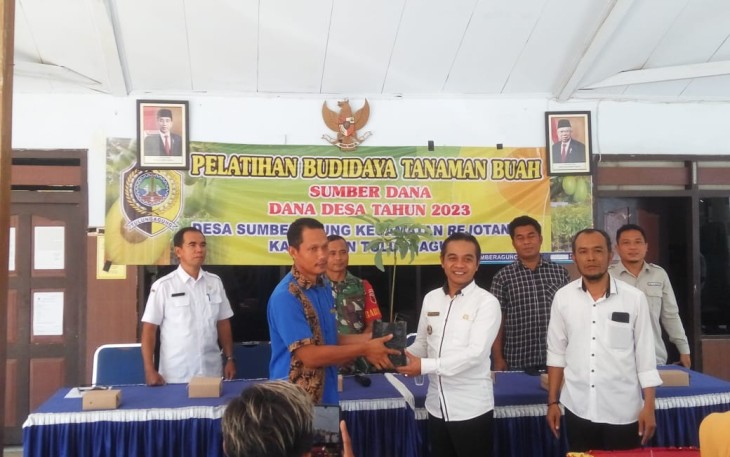 Kades Sumberagung Judian, S.Pd, M.Pd bersama Camat Rejotangan Didi Jarot secara simbolis memberikan bibit alpukat kepada salah satu Kader Karang Taruna Desa Sumberagung 