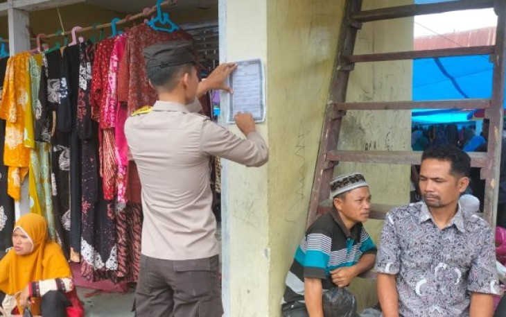 Personel Polsek Dolok menempel maklumat Kapolres Tapsel di sejumlah titik keramaian masyarakat.