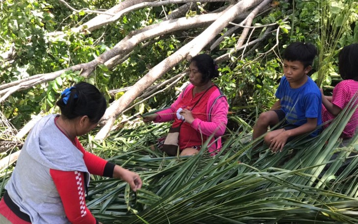 Warga tengah membuat sapu lidi dari pohon kelapa yang hasil gusuran oleh satgas TMMD 
