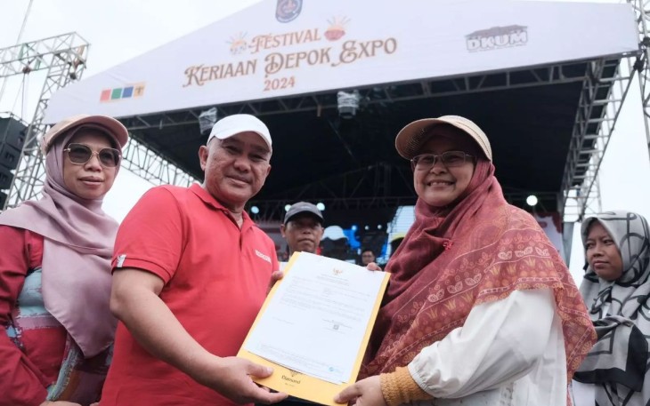 Wali Kota Depok, Mohammad Idris didampingi istrinya menyerahkan sertifikat kepada pendamping WUB dalam acara Depok Expo 2024, di Alun-alun Timur, GDC, Minggu (08/12/24)