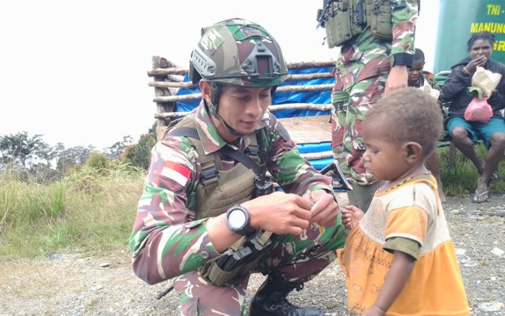 Satgas Yonif 509 Kostrad saat Bagikan Makanan pada seorang anak di Intan Jaya, Papua