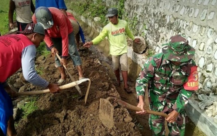 Babinsa Kodim Ponorogo saat turut Kerja Bakti Bersihkan Selokan