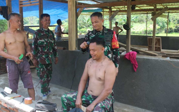 Dansatgas TMMD Kodim Parepare Letkol Kav S. Simanjuntak potong rambut anggotanya, Selasa (4/3)