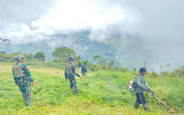 Satgas TNI Berjibaku Bersama Warga Siapkan Lokasi Bakar Batu dengan Semangat Kebersamaan di Kampung Wombru