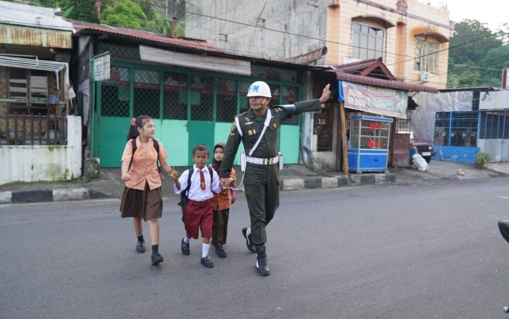 Anggota Denpom 1/2 Sibolga menyeberangkan anak sekolah