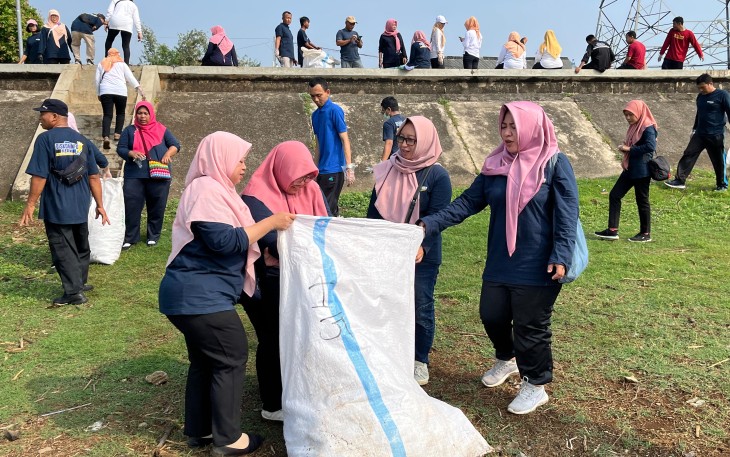 Para pegawai Diskominfo Karanganyar bergotong royong membersihkan sampah di kawasan Waduk Delingan, Jumat (8/8/2025).