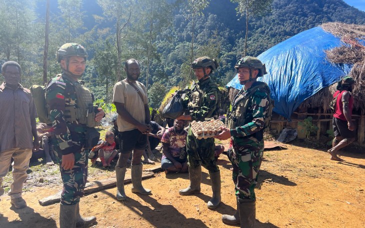 Satgas Yonif 700/Wyc saat menyapa warga dengan senyum dan membawa bahan makanan pokok sebagai bentuk kepedulian dan perhatian.