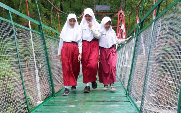 Sukacita siswa melintas di jembatan gantung perintis dusun Karang