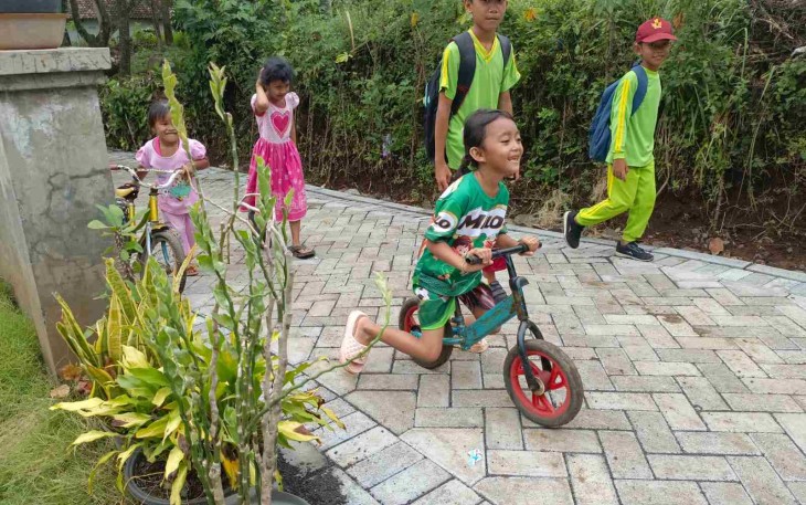 Anak-anak gembira bermain di jalan paving