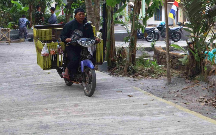 Pak Ramli penjual sayuran melewati jalan rabat beton