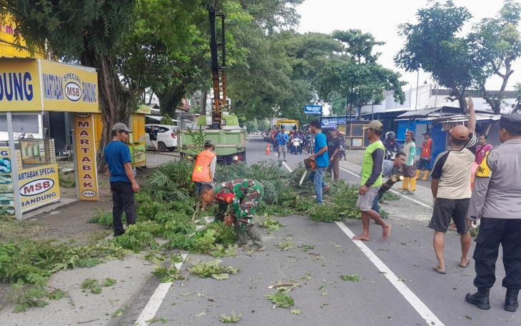 Babinsa Koramil 01/Ngawi dan Bhabinkamtibmas Pangkas Ranting Pohon Di Bahu Jalan 
