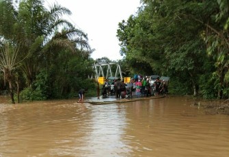 Banjir genangi jalan setinggi lutut orang dewasa. Motor terpaksa diangkut pakai rakit