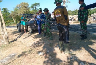 Personil TNI Dan Masyarakat Sedang Menurunkan Besi 