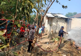 Tim pemadam bersama masyarakat berusaha memadamkan api 