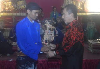 Bupati menyerahkan wayang sebagai tanda dimulainya pentas