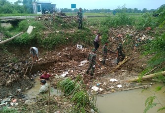 Anggota TNI-Polri dan Warga Bersihkan Sampah Saluran Irigasi