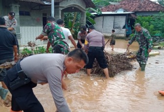 Anggota Koramil Wedarijaksa dan Shabara Polres Pati membersihkan sisa-sisa sampah banjir