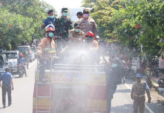 Dandim 0808/Blitar Letkol Inf Kris Bianto (dua dari kiri berdiri) saat menyemprotkan Disinfektan diatas Truk Damkar 