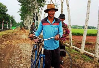 Sunoyo Warga Desa Pantirejo Saat Melintasi Jalan 