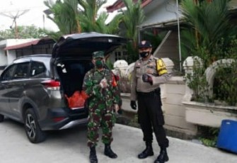 Babinsa 08 Batu Selicin Serka Dadang Hendarsah dan Bhabinkamtibmas Kelurahan Batu Selicin Polsek Lubuk Baja Aipda Doni Admiral saat mempersiapkan sembako yang akan dibagikan kepada masyarakat