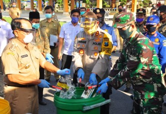 Dandim 0808/Blitar Letkol Inf Kris Bianto saat memusnahkan Botol Miras. (foto : Crew Klikwarta.com) 